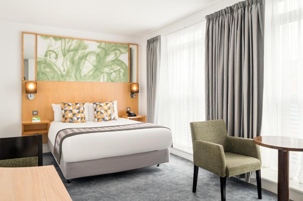 une chambre d'hôtel avec un lit, une table et une chaise dans l'établissement Holiday Inn Birmingham City, an IHG Hotel, à Birmingham