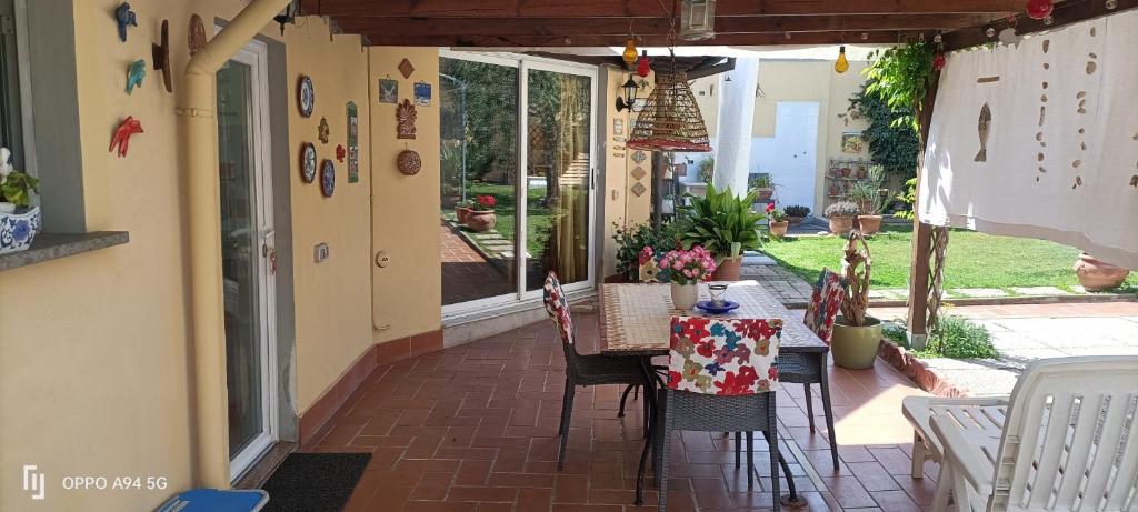 porche con mesa y sillas en el patio en Casa in giardino, en Piombino