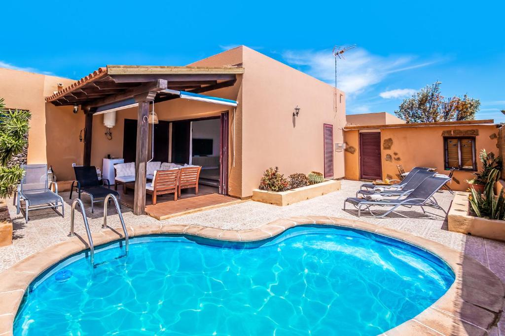 ein Haus mit einem Pool und einer Terrasse in der Unterkunft Villa Tropical Private Pool Capellania By Holidays Home in La Oliva