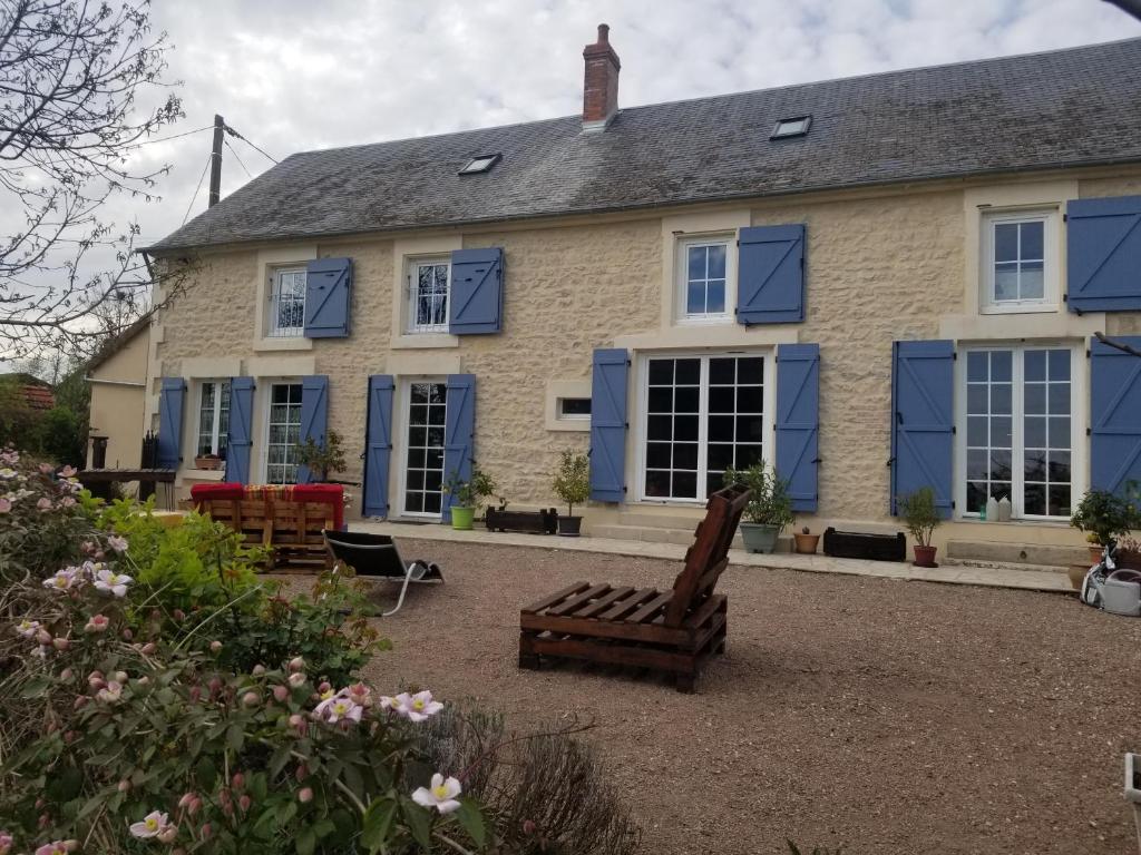 a house with blue shutters and a bench in front of it at Chambre d'hôtes Chez Léon pour 1 à 4 personnes in Chaulgnes