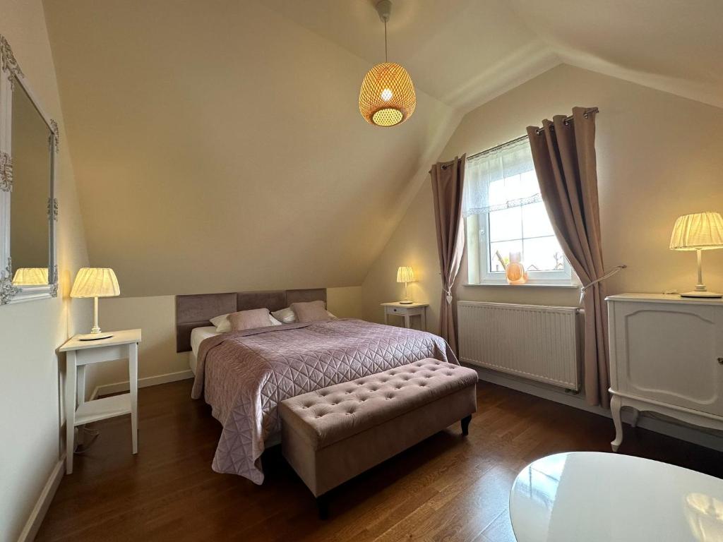 Schlafzimmer mit einem Bett und einem Fenster in der Unterkunft APARTAMENTY "LA VILLA" z klimatyzacją, ogrodem i parkingiem in Kudowa-Zdrój