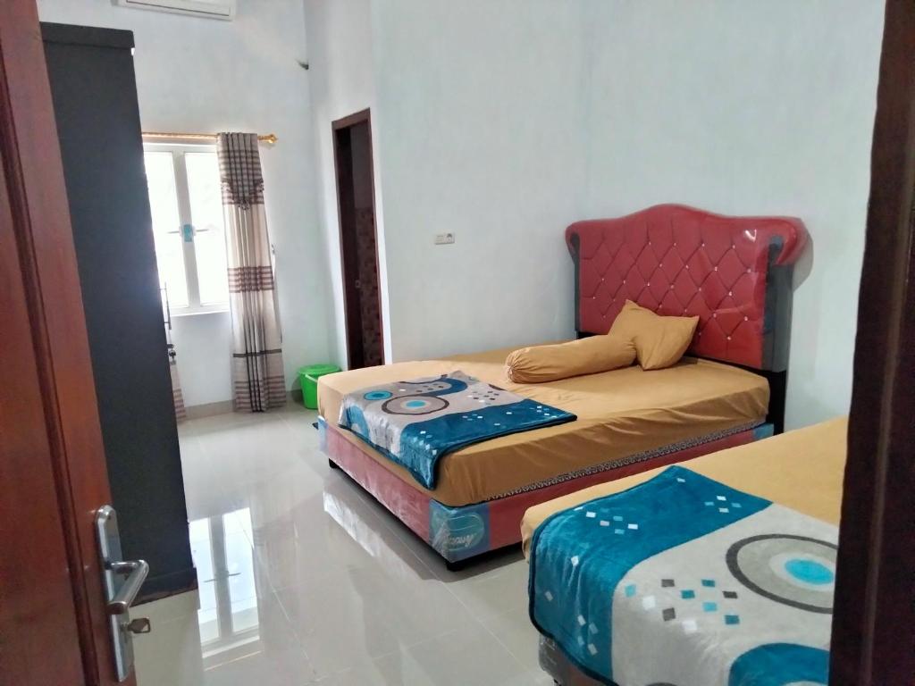 a room with a bed and a couch in it at Domen homestay syariah krui 64 in Krui