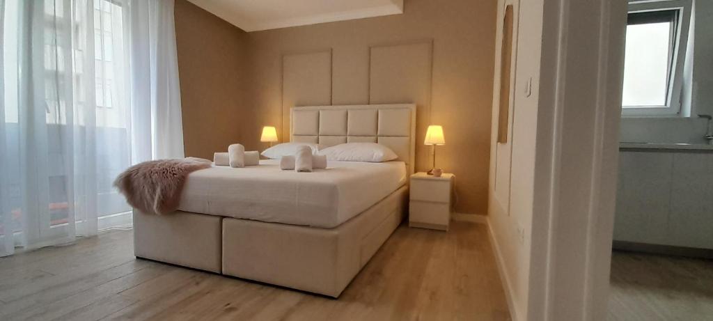 a bedroom with a white bed with two candles on it at Maboka Studio in Zadar