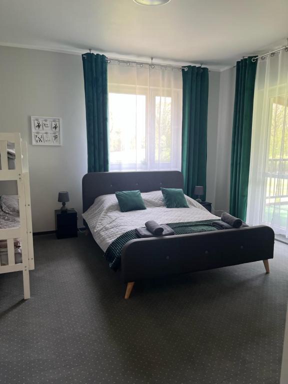 a bedroom with a large bed with green curtains at Camping Bystry in Giżycko