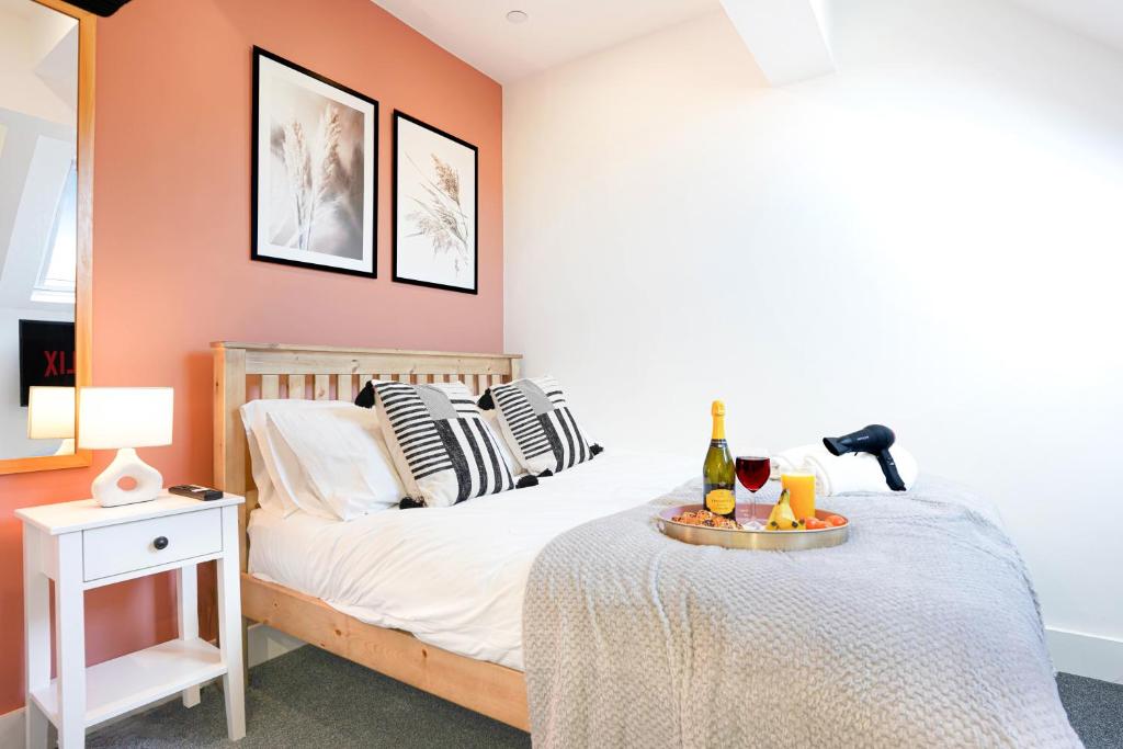 a bedroom with a bed with a tray of wine bottles at Central Buckingham Apartment #7 with Free Parking, Pool Table, Fast Wifi and Smart TV with Netflix by Yoko Property in Buckingham