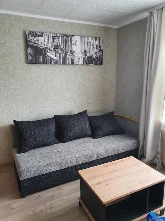 a living room with a couch and a table at Apartament Erfolg 7 in Daugavpils