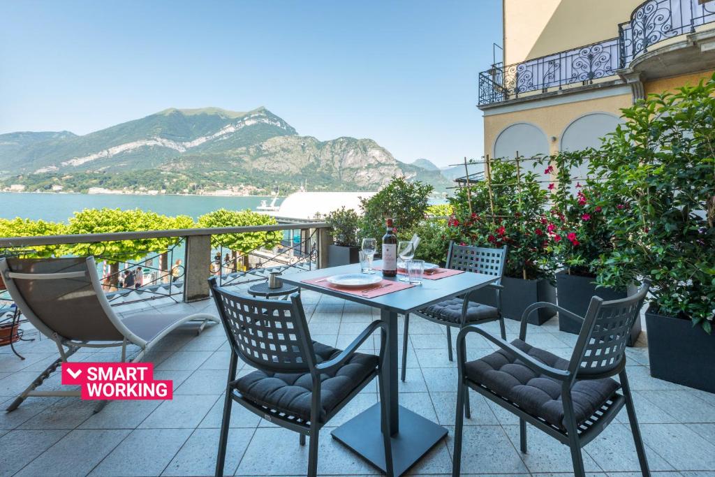un tavolo e sedie su un balcone con vista sull'acqua di Terrazza Mazzini Stylish by Wonderful Italy a Bellagio