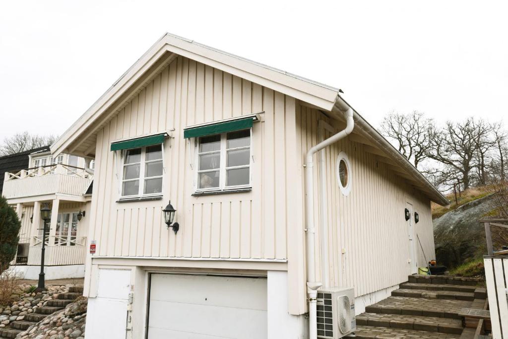 a white house with a door and a garage at Nice independent holiday apartment on Saro in Särö
