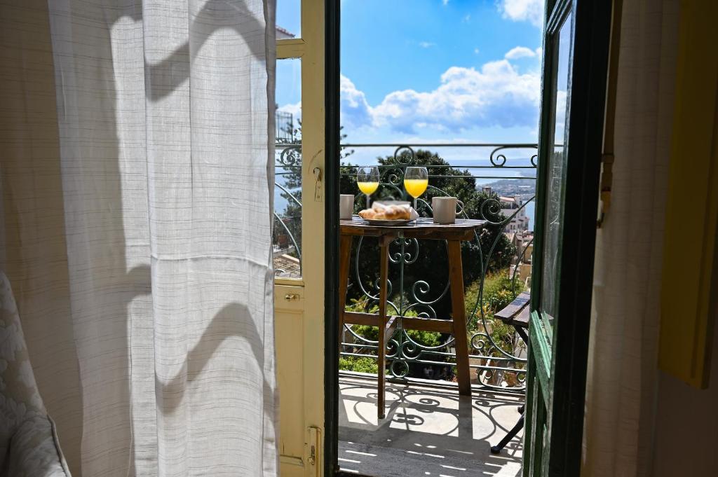 een balkon met een tafel met 2 glazen wijn bij Paradisea Taormina Theatre in Taormina