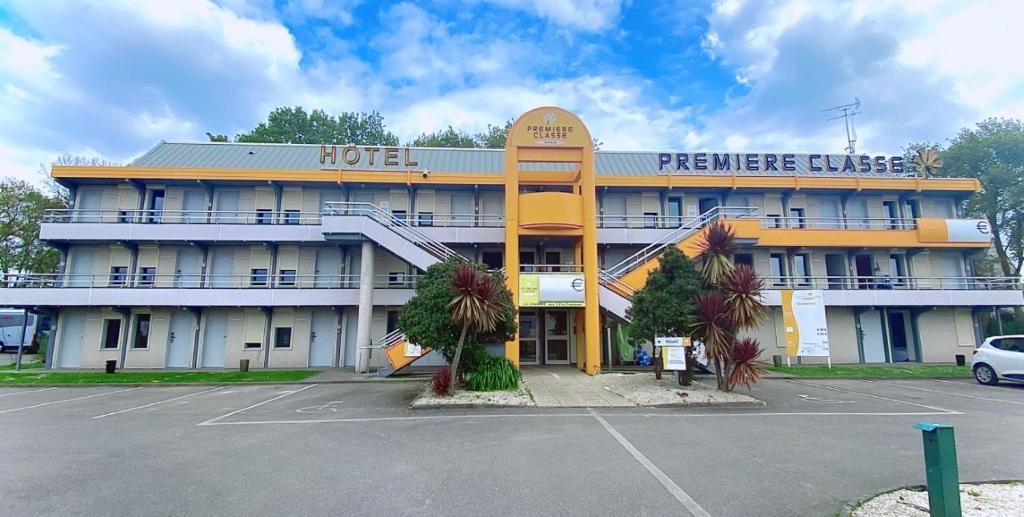 a hotel with a parking lot in front of it at Premiere Classe Quimper in Quimper