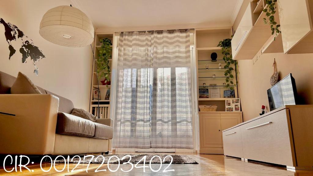 ein Wohnzimmer mit einem Sofa und einem Fenster in der Unterkunft Trilocale Parco del Valentino in Turin