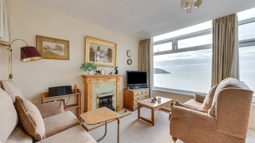 a living room with a fireplace and a view of the ocean at Redcliffe Apartments E in Bishopston