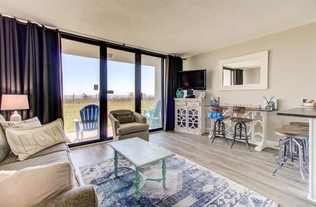 a living room with a couch and a table at 0103 Relax You're At The Beach by Atlantic Towers in Carolina Beach