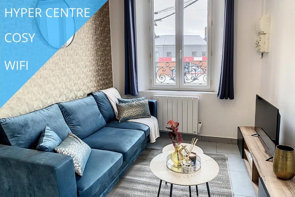 - un salon avec un canapé bleu et une table dans l'établissement Appart Hyper Centre Tout Confort Wifi 4 Pers, à Romilly-sur-Seine
