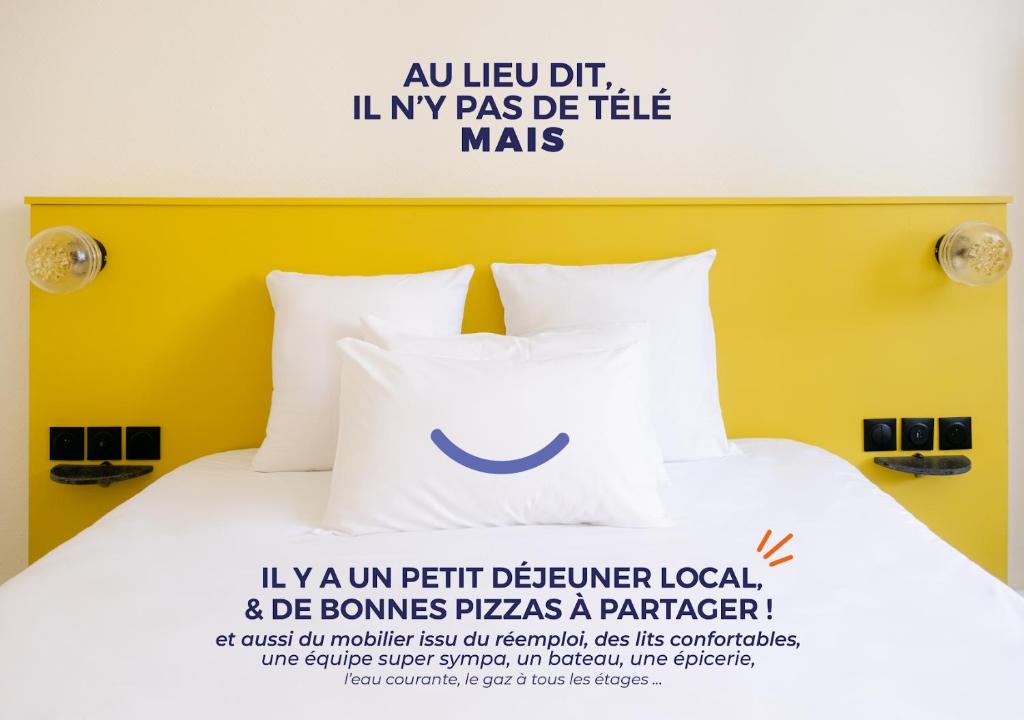 a bed with a pillow with a smile on it at Le Lieu Dit in Nantes