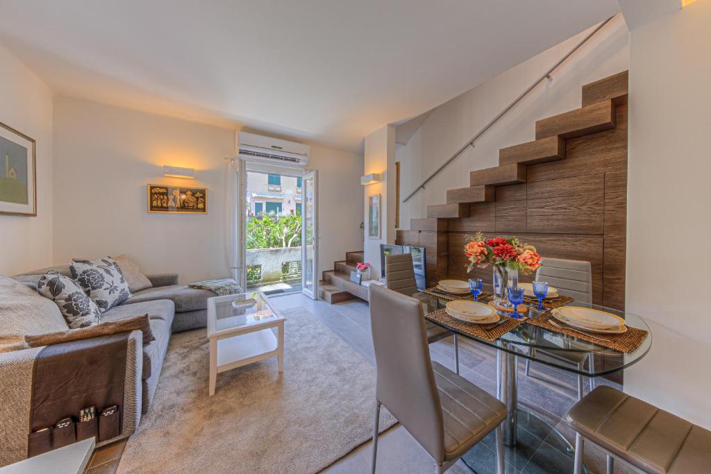 ein Wohnzimmer mit einem Sofa und einem Tisch mit Blumen darauf in der Unterkunft VILLA TORETTI Centro, Relax e Parcheggio Privato in Rapallo