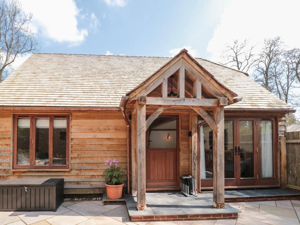 a wooden cabin with a large glass door at Beech Barn The Rookery in Kingsbridge