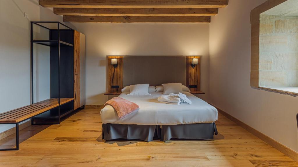 Palacio de los Acevedo في هوزنايو: غرفة نوم مع سرير أبيض كبير في غرفة