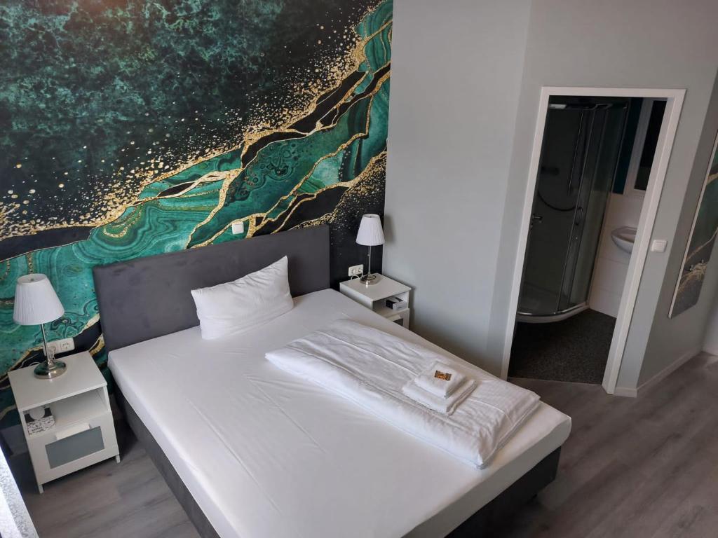 Schlafzimmer mit einem Bett mit Wandgemälde in der Unterkunft CASILINO Hotel A 20 Wismar in Wismar