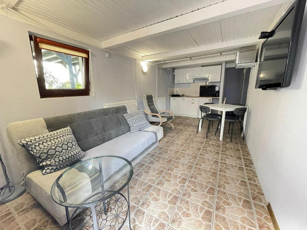 ein Wohnzimmer mit einem Sofa und einem Tisch in der Unterkunft Noclegi nad jeziorem w Puszczy Zielonka in Kamińsko