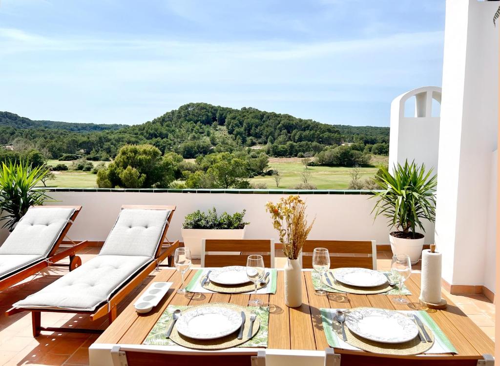 a dining room with a table and chairs on a balcony at Apartamento Atardecer en Menorca Son Parc Vista al campo de golf in Son Parc