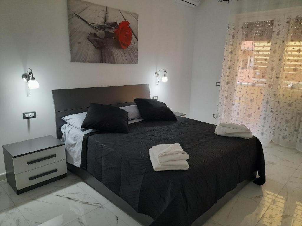 a bedroom with a black bed with two towels on it at DREAM HOUSE in Lido di Ostia