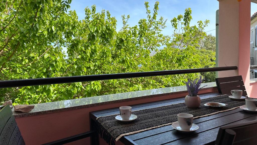 een tafel met kopjes en schotels op een balkon bij Apartment Murva in Premantura