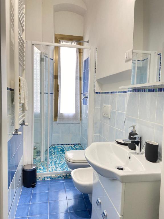 a blue and white bathroom with two toilets and a sink at Paolina Home in La Spezia