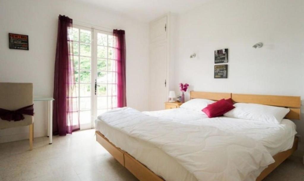 - une chambre avec un grand lit blanc et des oreillers rouges dans l'établissement Magnifique Maison avec piscine sans vis à vis 4 chambres et 1 mezzanine dans un milieu verdoyant, à Saint-Jean-du-Gard