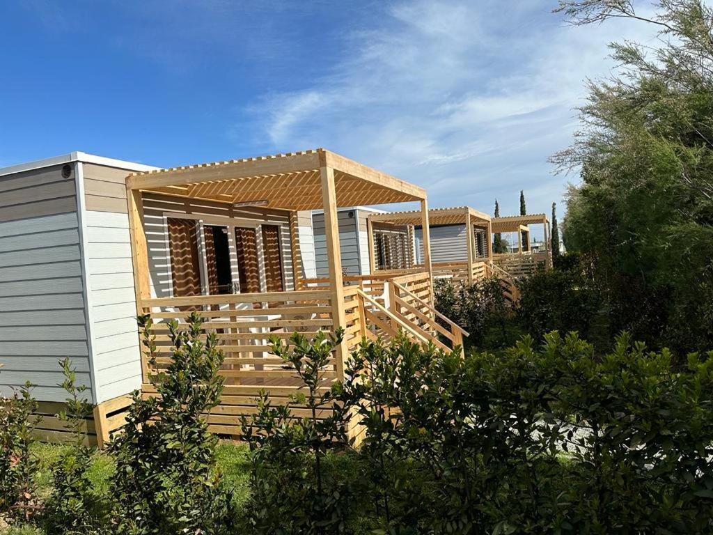 uma casa com um deque de madeira com uma pérgola em Agricampeggio Ippocampo em La Cinquantina