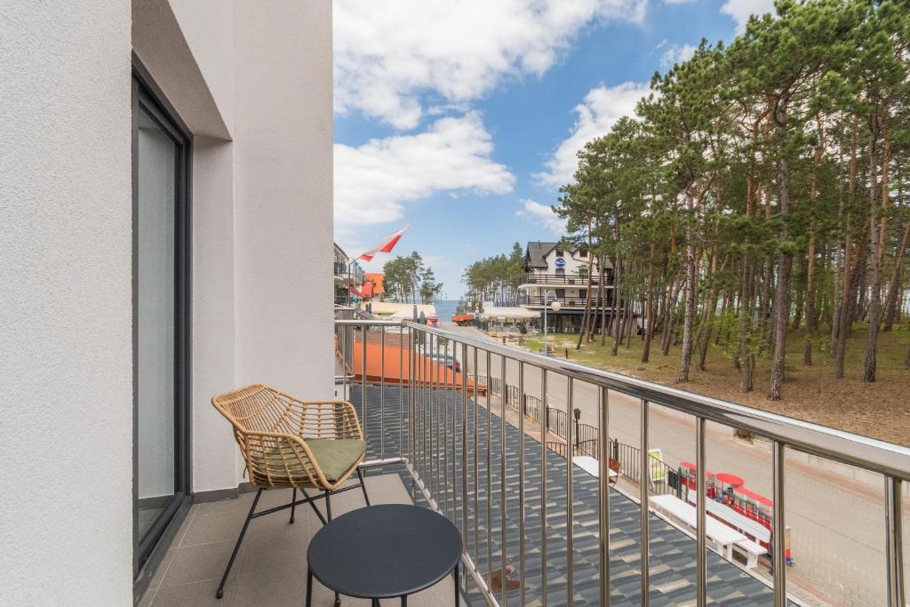 a balcony with chairs and a view of a beach at uTadka in Sztutowo