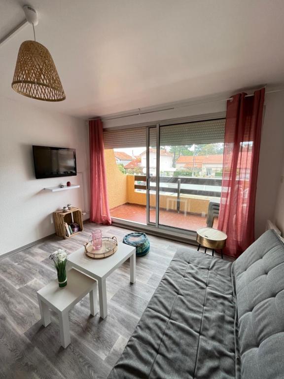 a living room with a couch and a table at Appartement Argelès-sur-Mer avec piscine à 500m de la mer in Argelès-sur-Mer