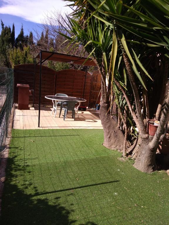 d'une terrasse avec une table de pique-nique et de l'herbe verte. dans l'établissement Villa lilousa, à Le Soler