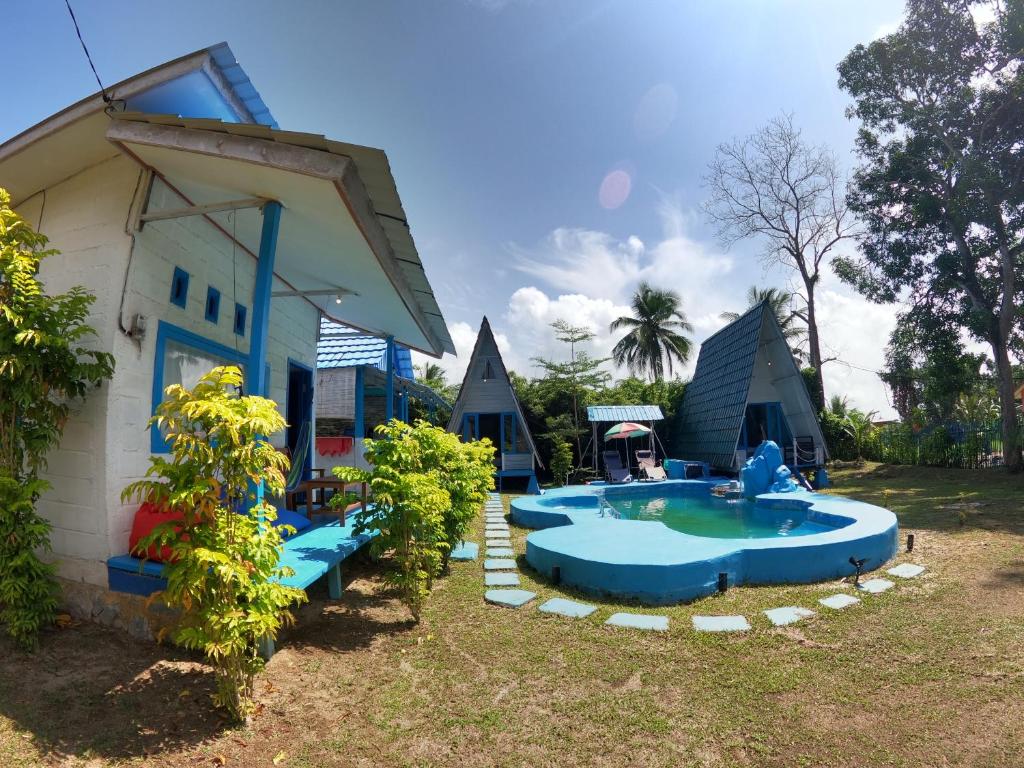 Sijuk的住宿－Tanjong Tinggi Cottage，庭院里一群带游泳池的房屋