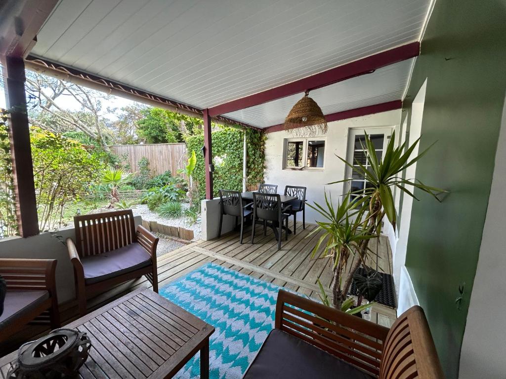 une véranda avec une table et des chaises dans l'établissement Le Panier Fleuri, à Lacanau