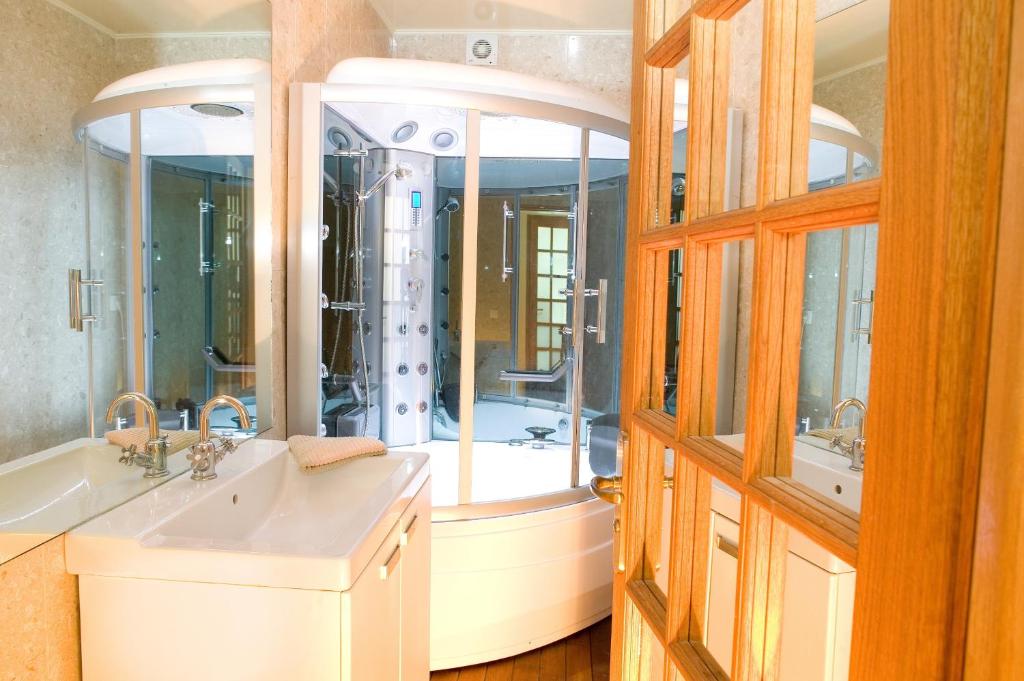 a bathroom with a tub and a sink and a mirror at Abbesses Montmartre Apartment in Paris