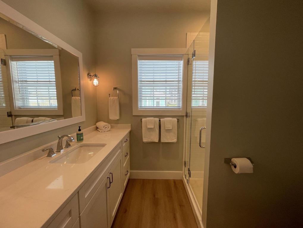 a bathroom with a sink and a mirror and a shower at Key West Cottages in Chincoteague