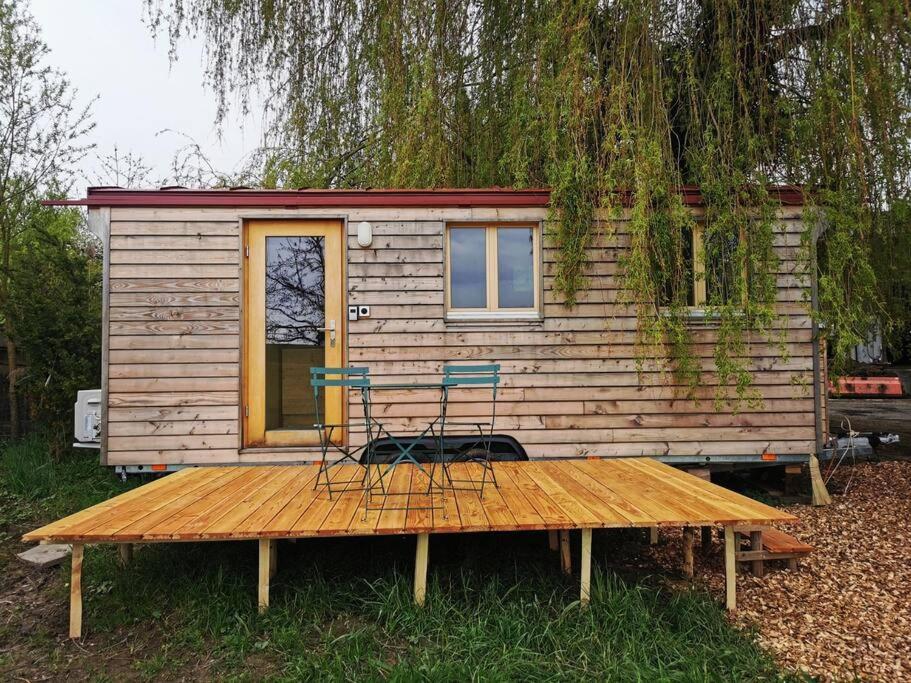 een tiny house met twee stoelen op een houten terras bij Schäferwagen Hygge nähe Reuss in Gisikon
