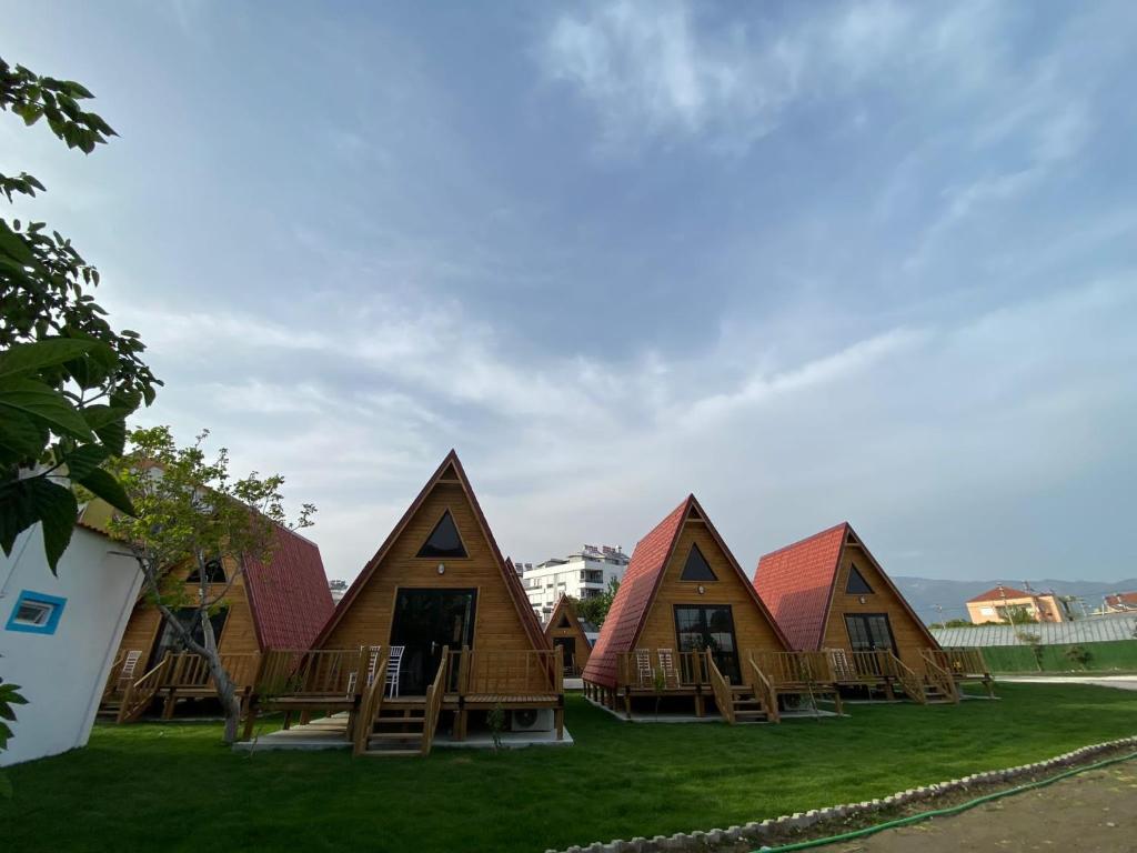 a group of houses with red roofs on the grass at NOEL BUNGALOV & CAFE in Demre