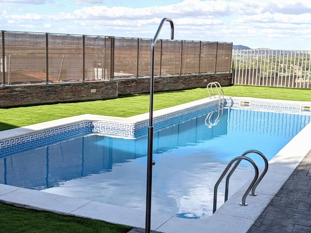 a swimming pool with blue water in a yard at La Martela de Segura Apartamento rural piscina in Segura de León