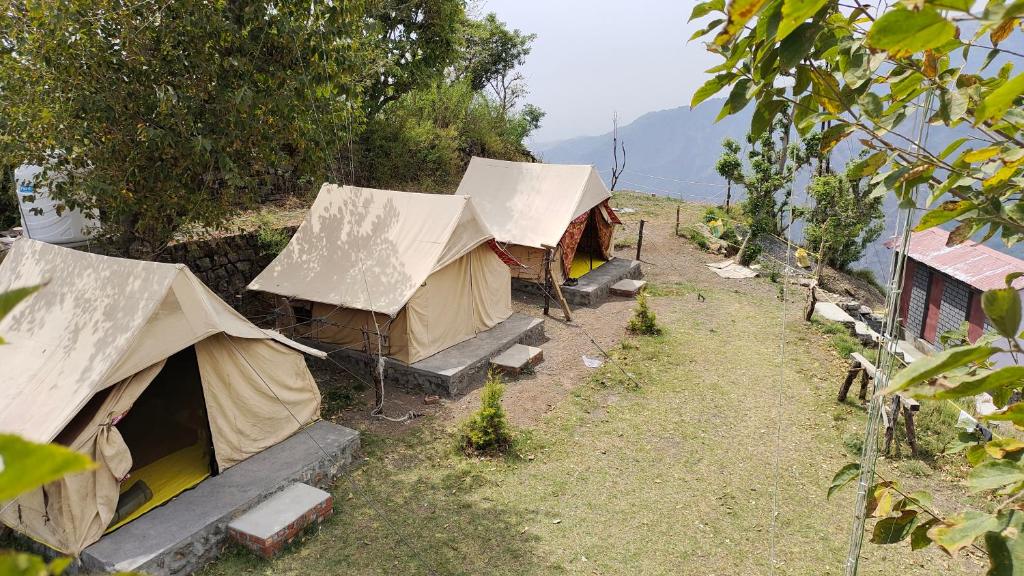 a group of tents sitting on top of a hill at Shakoon Camps & Farmstay Nainital in Nainital