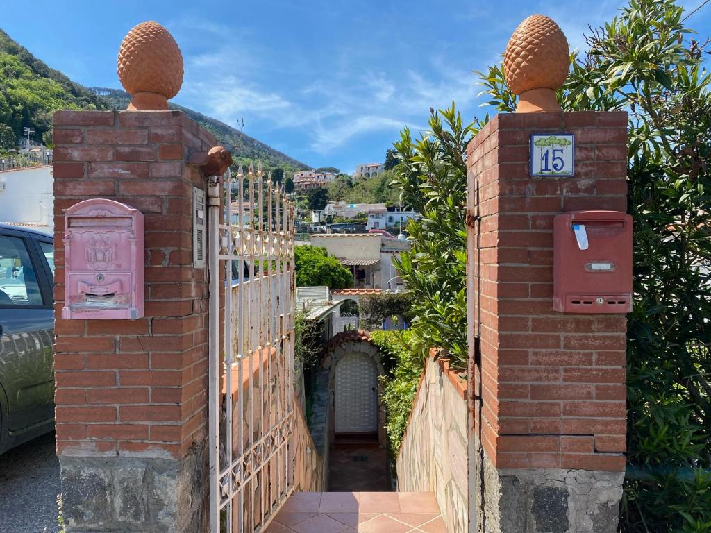 a gate with a clock on it with a fence at Casa Wanda - Restyled 2026 Edition Holiday Home, Ischia Center in Ischia Town