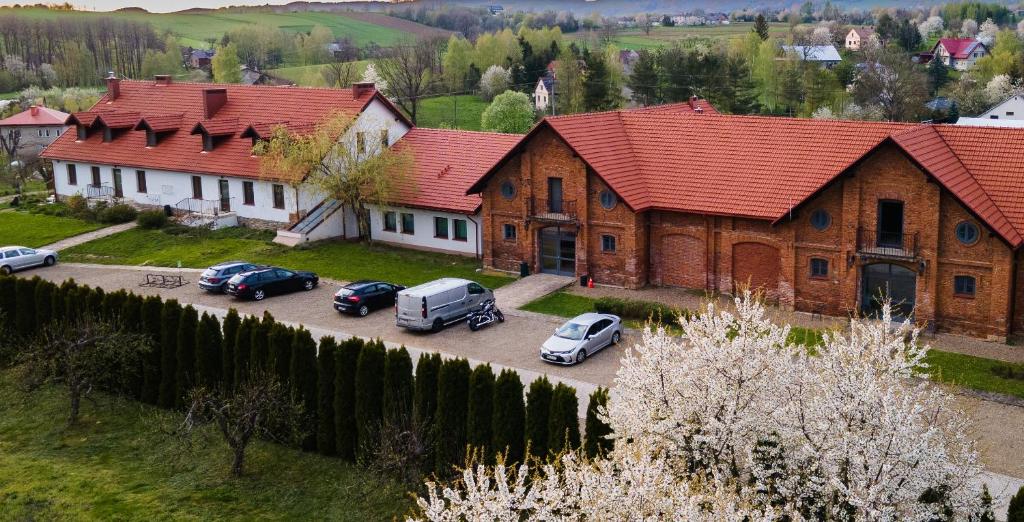 une grande maison avec des voitures garées dans un parking dans l'établissement Dwór Kombornia - Folwark, à Kombornia