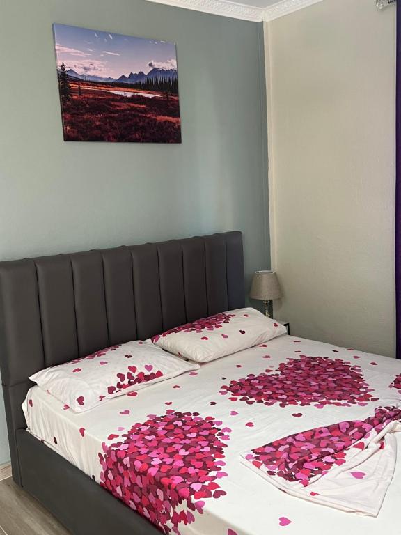 a bed with a bunch of pink hearts on it at VILA AARON in Durrës