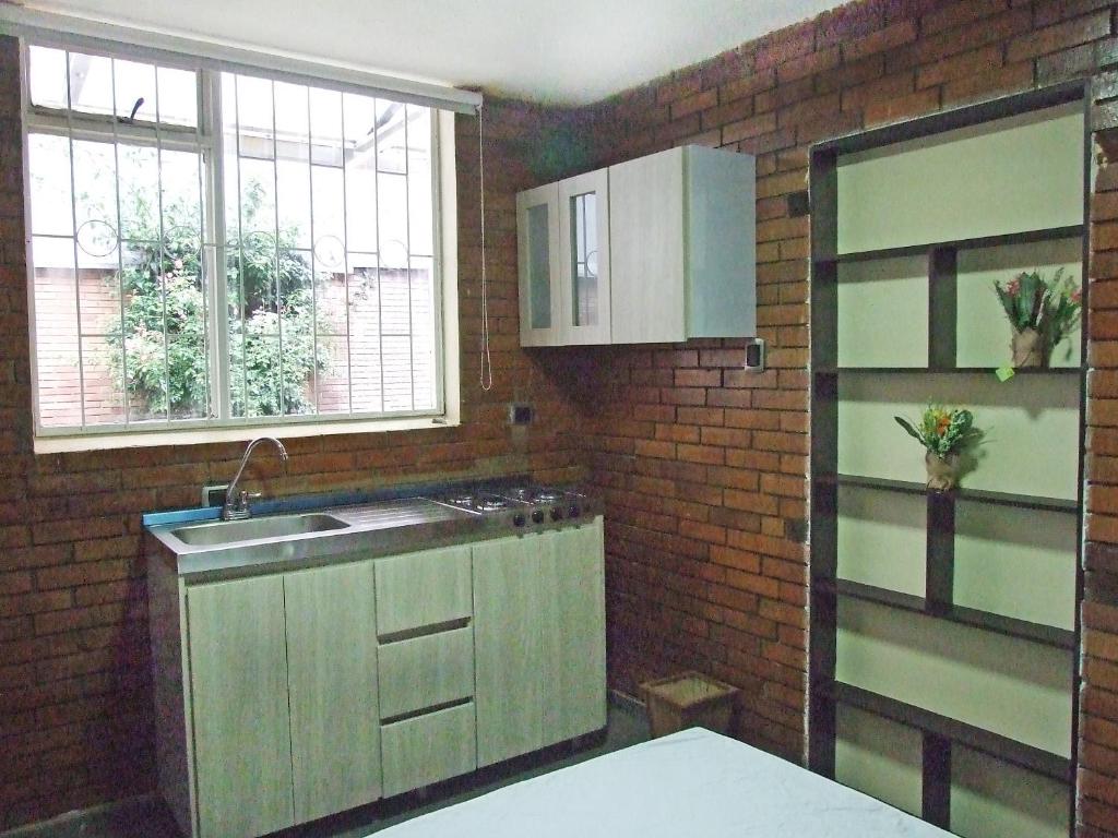 a kitchen with a sink and a brick wall at Roma House N- suite Campin Movistar Ministerios Simón Bolivar in Bogotá