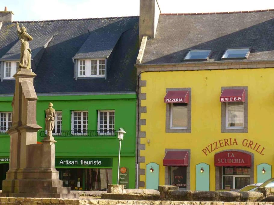 a statue in front of buildings in a town at Kerletty, la mer, les embruns, à 250 m des plages in Plouguerneau