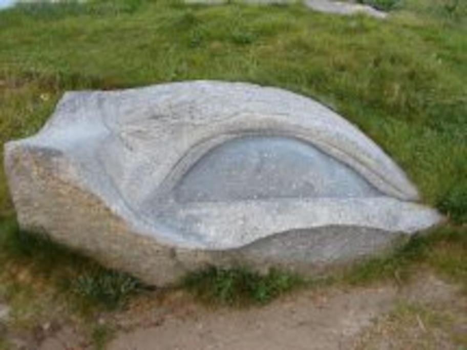 a large rock sitting in the grass at Kerletty, la mer, les embruns, à 250 m des plages in Plouguerneau