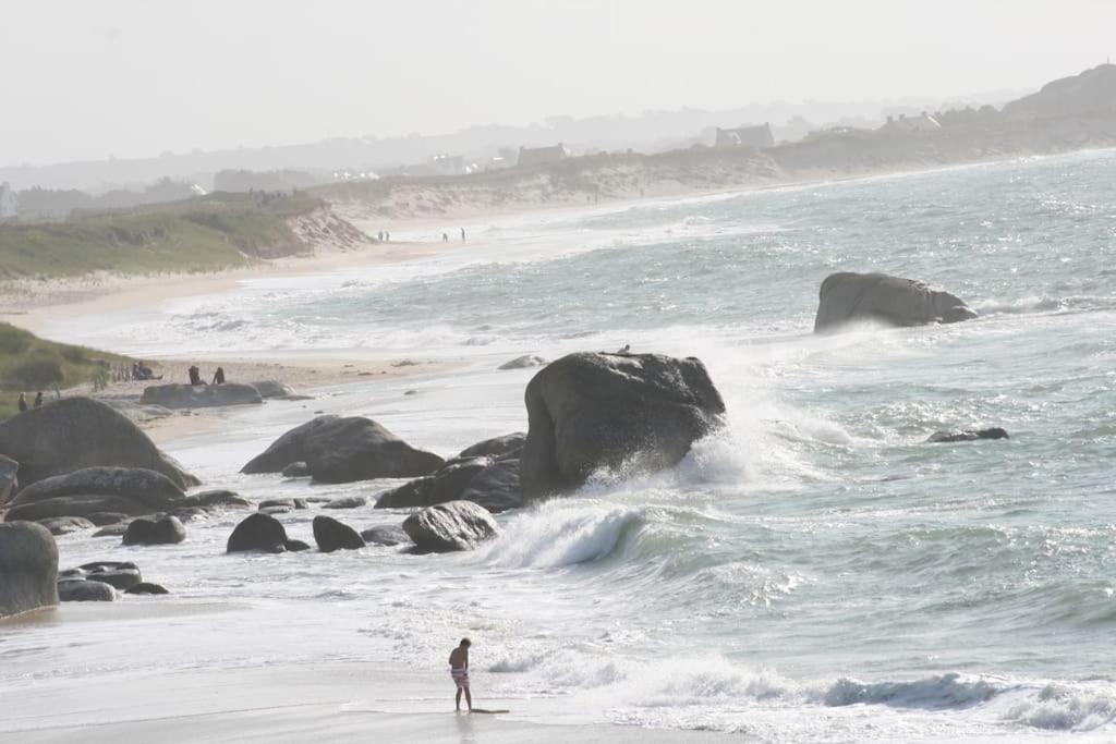 a person standing on a surfboard in the ocean at Kerletty, la mer, les embruns, à 250 m des plages in Plouguerneau