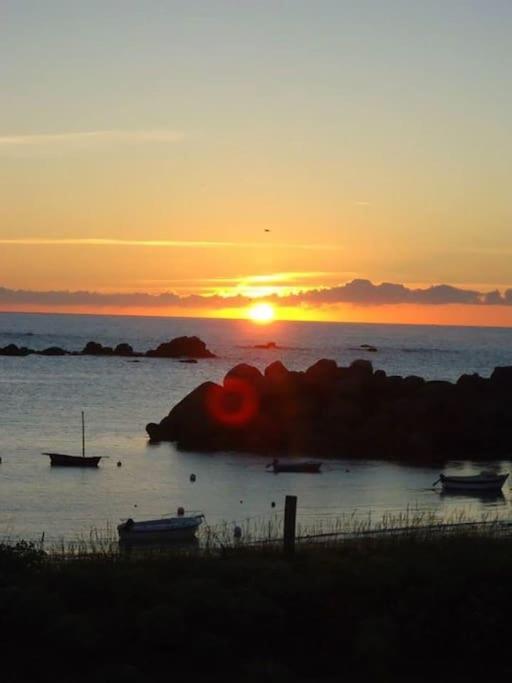 a sunset over the ocean with boats in the water at Kerletty, la mer, les embruns, à 250 m des plages in Plouguerneau