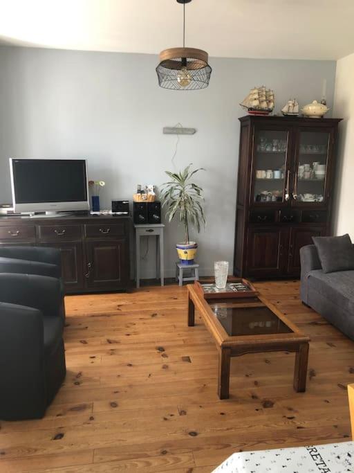 a living room with a couch and a coffee table at Kerletty, la mer, les embruns, à 250 m des plages in Plouguerneau